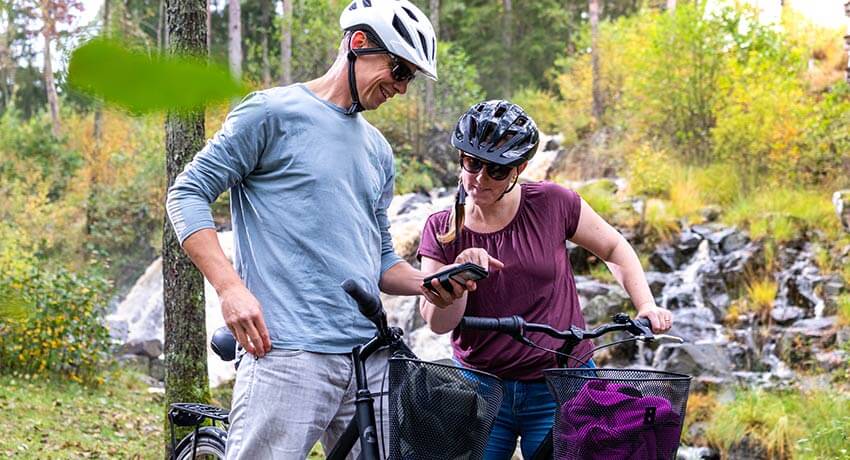Two people look at a map on their mobile phone along Hylteleden