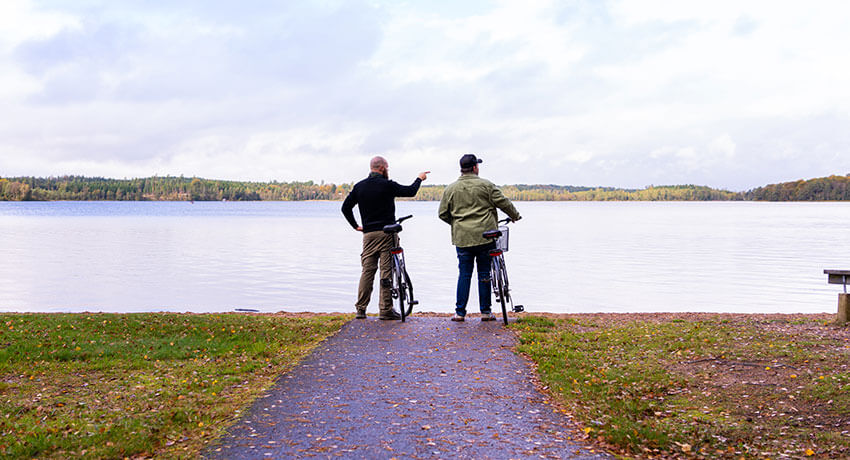 Två cyklister vid en sjö längs Hylteslignan